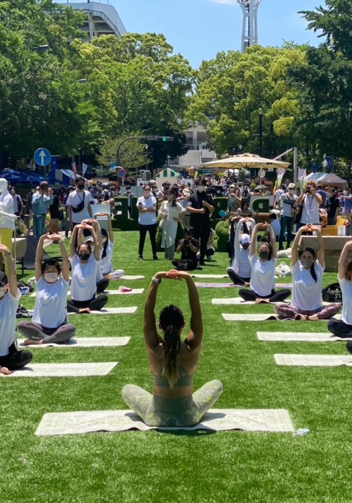 tvk かながわMIRAIストリートの人工芝の上でヨガをする様子